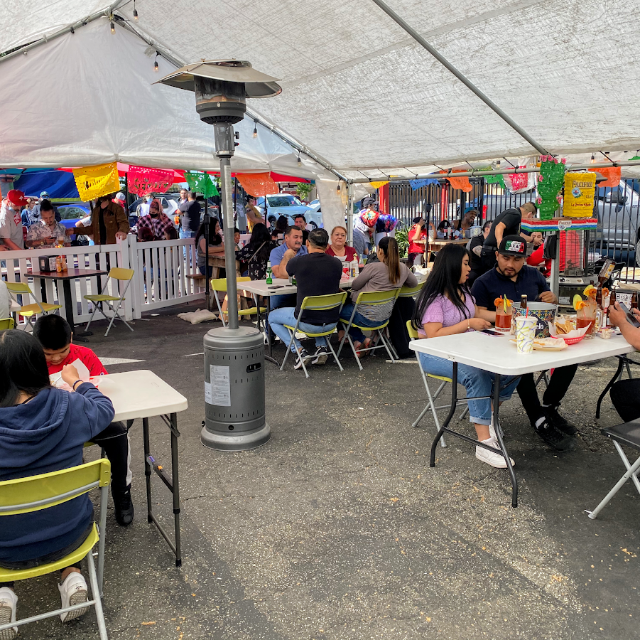 Guests dining under papel picado on the Mariscos Costa Alegre patio
